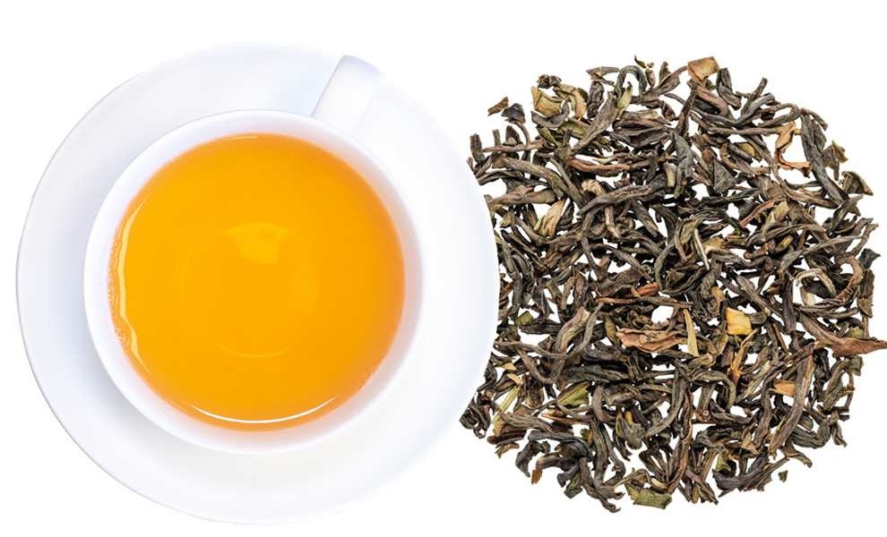 Weiße Tasse mit Schwarztee neben losem Blatttee, Tee, Blätter, Klarer Honigartige Flüssigkeit