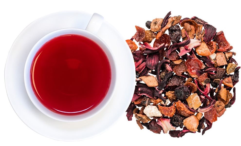 Weiße Tasse mit rotem Früchtetee und Teemischung, Kräutertee, Teetasse, Teeblätter, rote Infusion, lose Blätter Tee