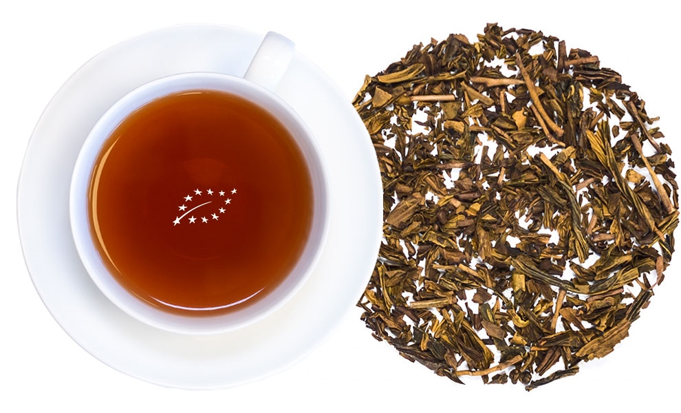 White cup of green tea with loose tea leaves