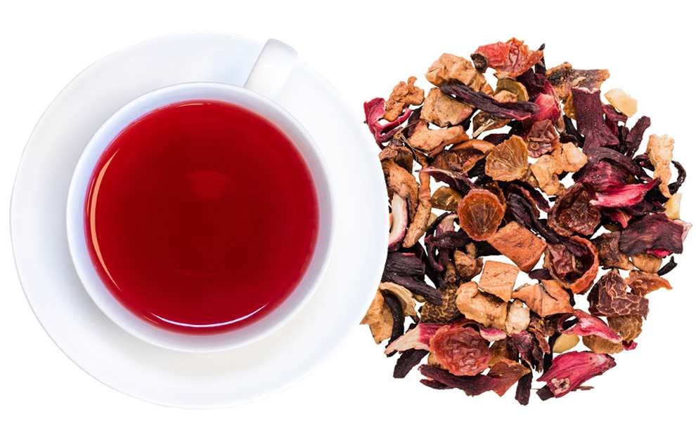 Rote Tasse Früchtetee neben loser Teemischung, Hagebuttetee, Rosen-Tee, Früchtetee, Kräutertee, Beerenmischtee