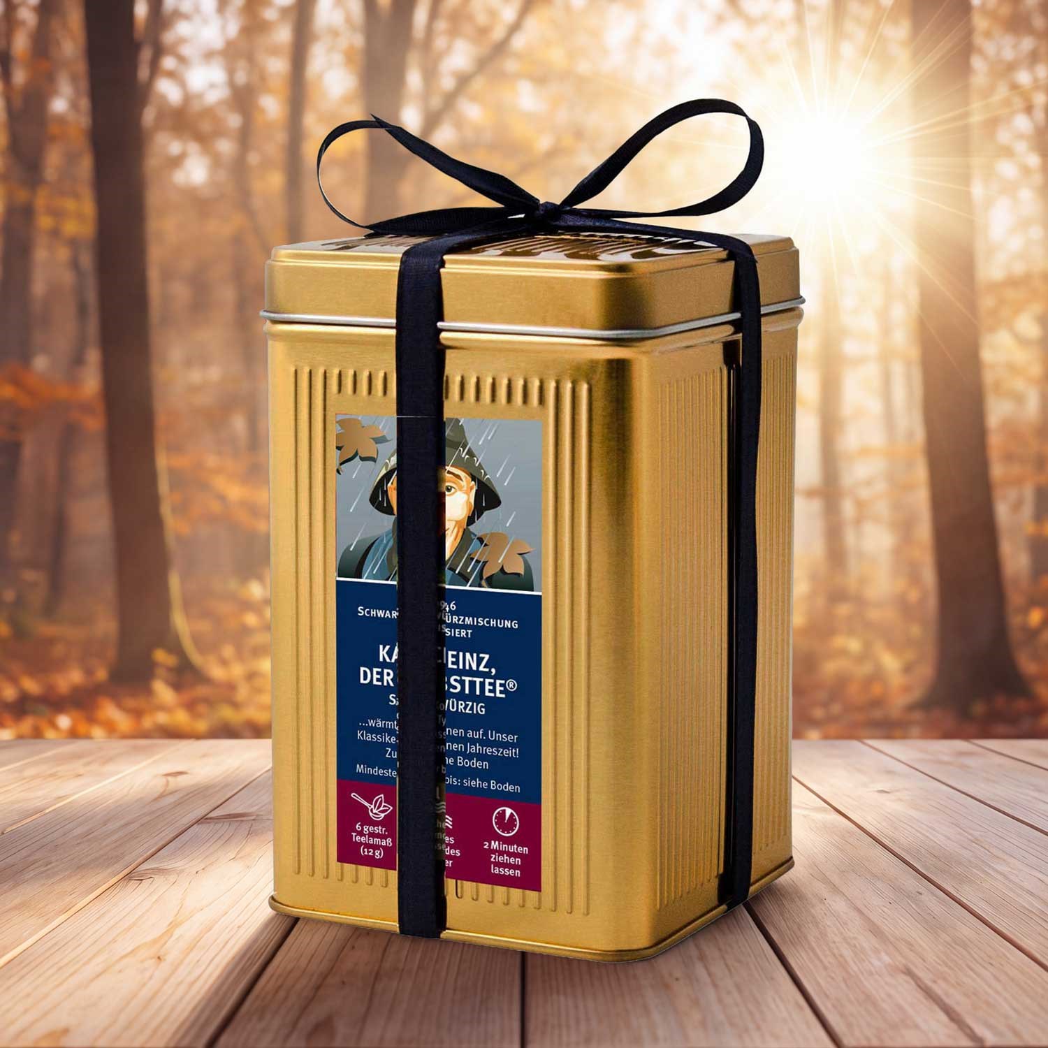 Goldene Teedose mit schwarzem Geschenkband auf Holz, Gourmet-Geschenkbox,  Metallbox,  goldfarbig,  Tees/Gewürzbehälter,  Herbstdekoration, Metalverpackung, Geldgeschenk-Box, Gelb/Gold, Schwarz Band, Etikett/Label