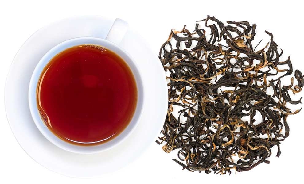 Weiße Tasse mit schwarzem Tee und losen Teeblättern, Tee, Schwarztee, Teeblätter, Teeausschnitt, Koffein?