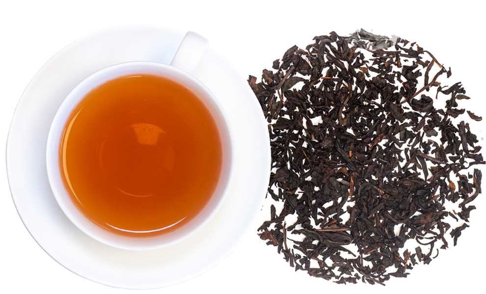 Weiße Tasse Schwarztee neben losen Teeblättern, tee, tee_blatt, kessel, tea, rauchig_braun