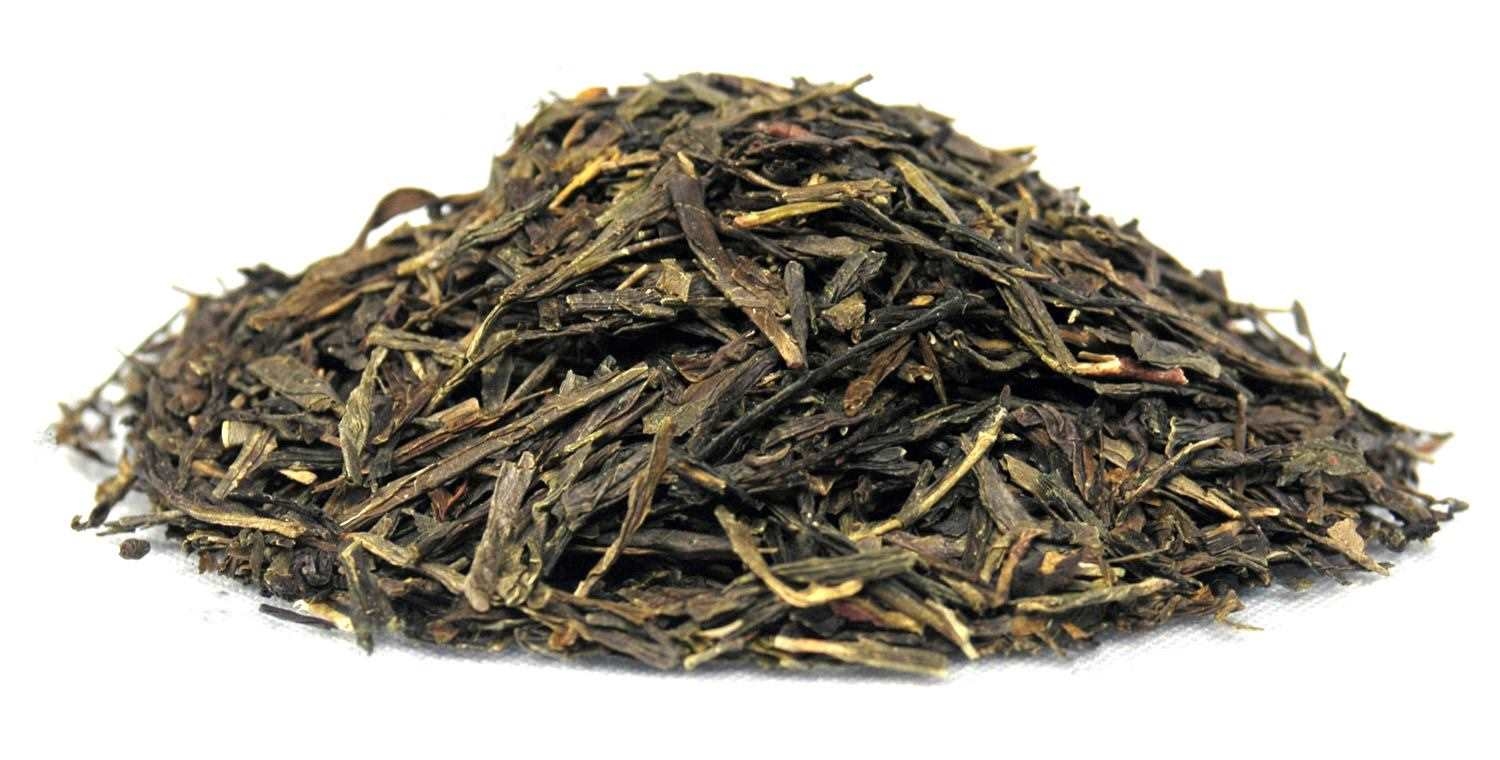 Pile of loose green tea Sencha with dried, flat-pressed tea leaves