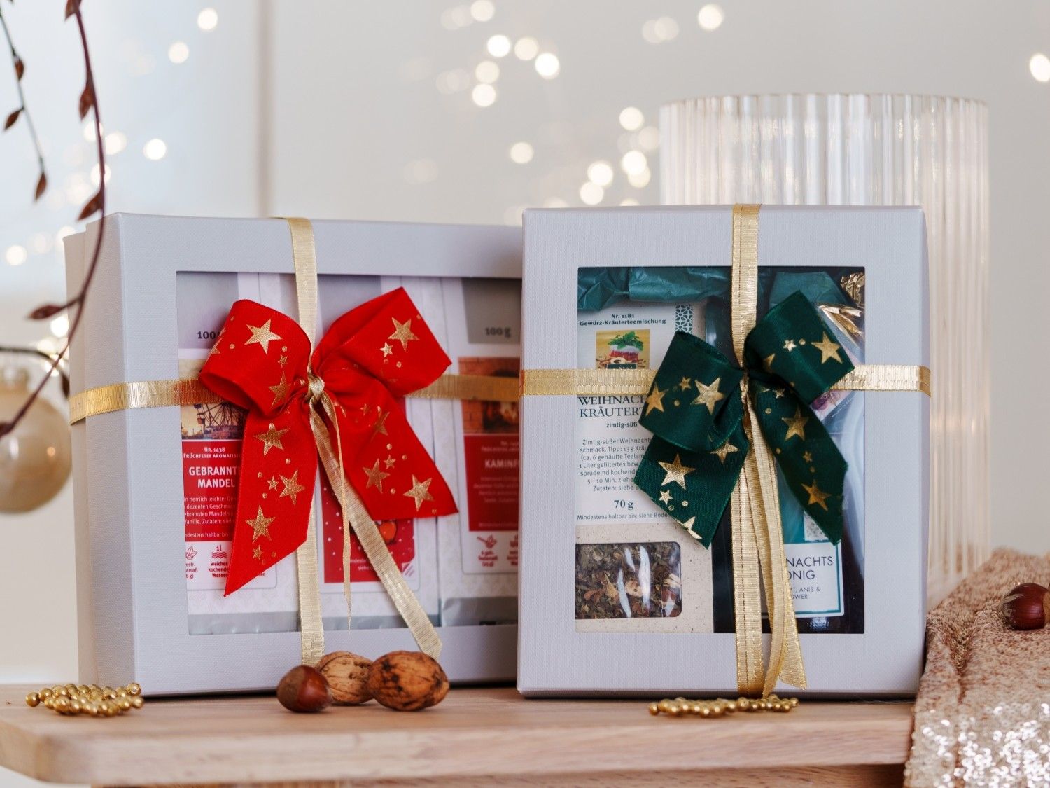 Weihnachtsgeschenkboxen mit Schleifen und Tee-Set auf Holz
