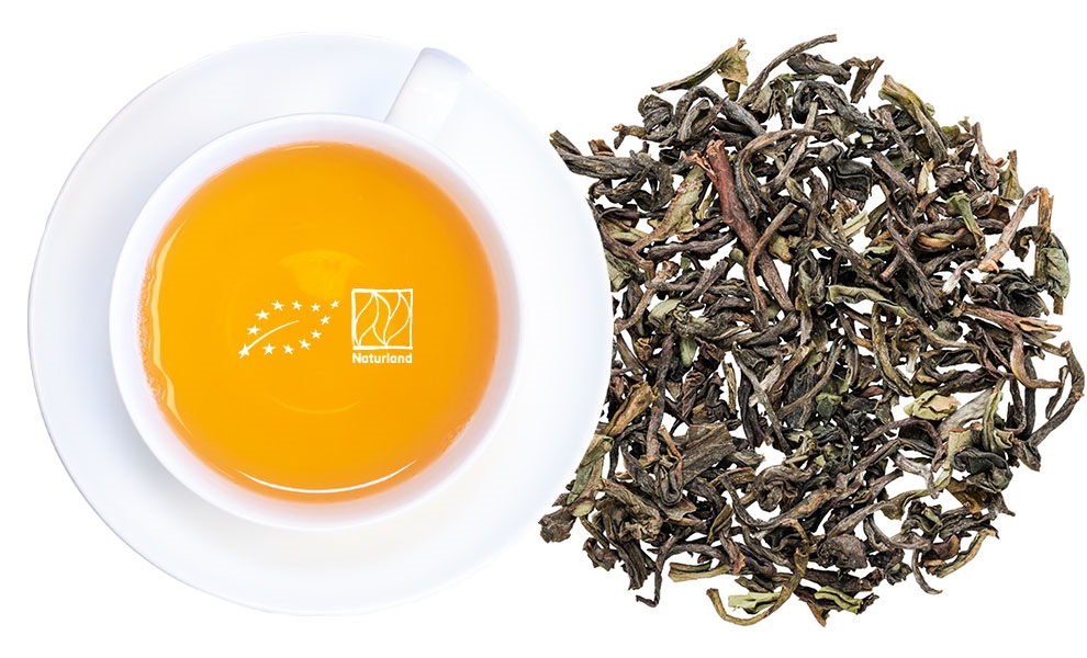 Weiße Teetasse mit losem Blatttee daneben, tee, teeblatt, teegetränk, bio tee, kräutertee