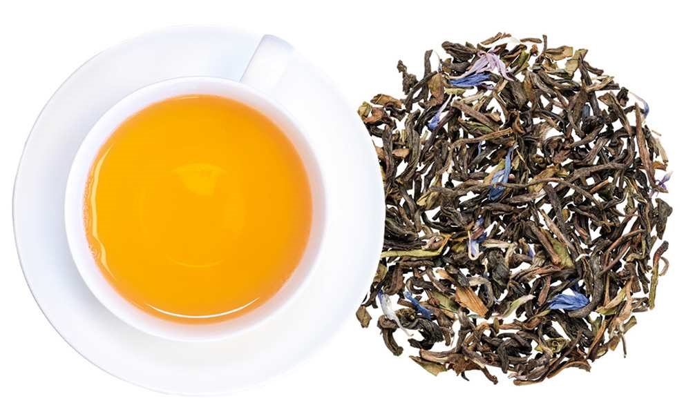 Weiße Tasse Tee mit losem Blatttee daneben, tee, tee-aufguss, grüner-tee, gelber-tee, blatt-tee