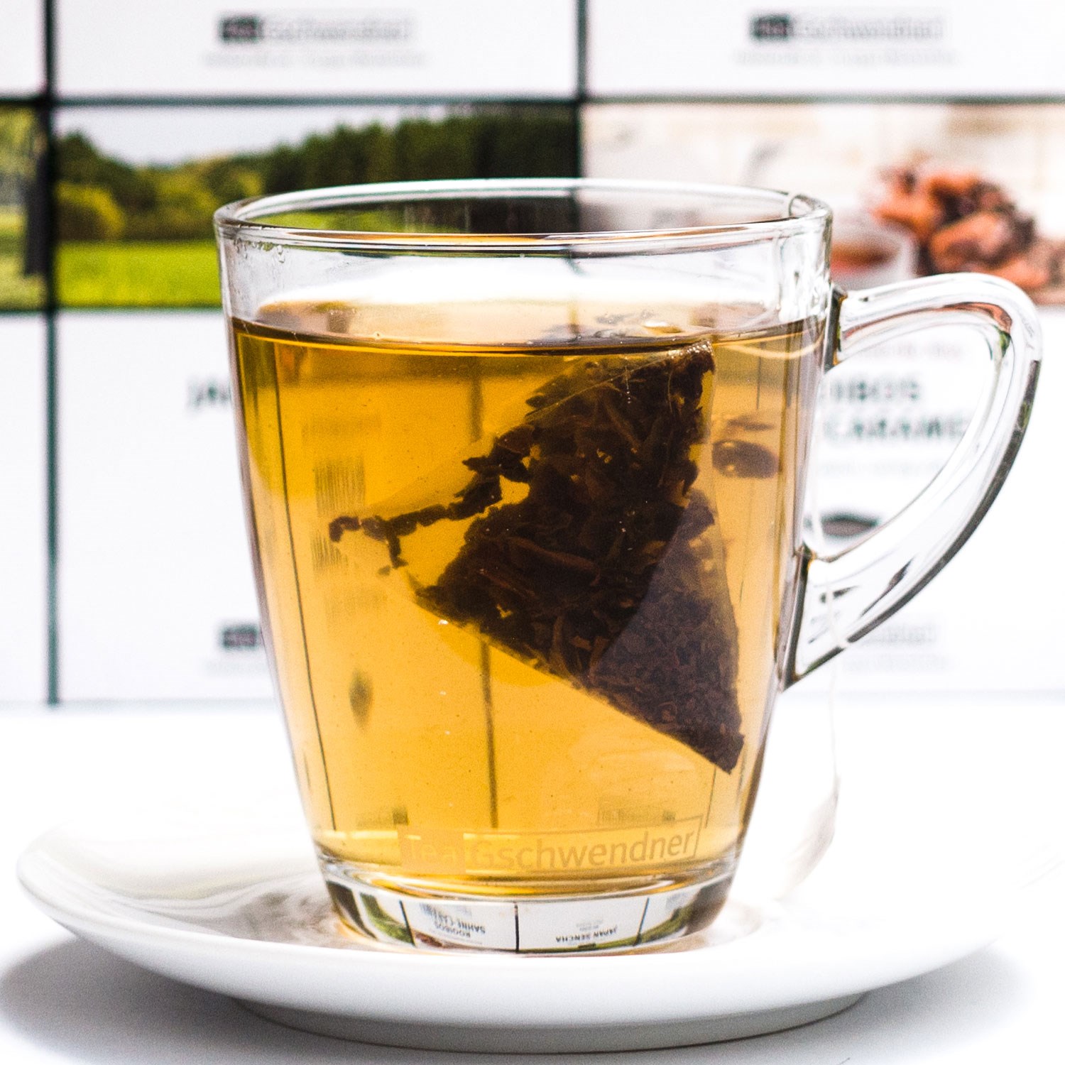 Transparente Teetasse mit losem Schwarztee auf Unterteller,  Kräutertee, zeit, zutaten, Moldawischer Balm, Pyramide, Tee, Glas, Kanne, Klarer Tee, Teebeutel, Teeglas, Teeblätter, Klarer Tee, Glasbecher, Kaffeetee
