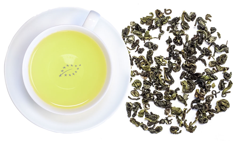 White cup filled with freshly brewed green tea