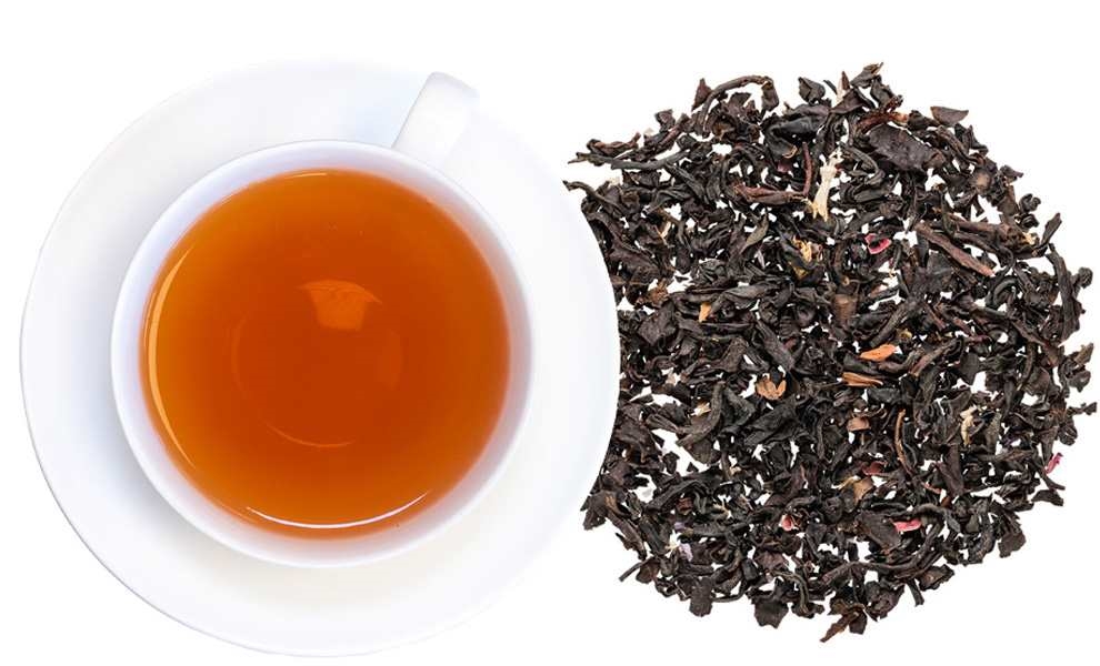 Weiße Tasse mit schwarzem Tee und losem Blatttee daneben, Tee, Schwarztee, Teeblätter, Aufguss, Küche