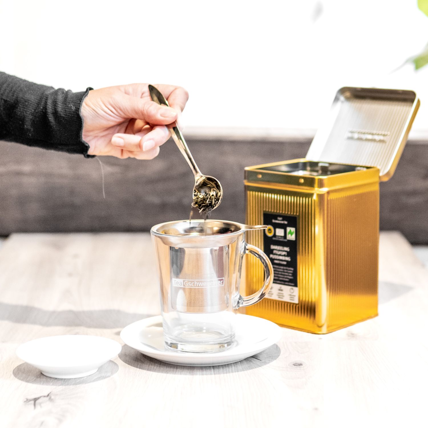 Hand dosiert losen Tee in Filterglasbecher