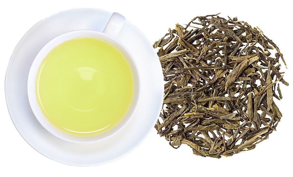 Tasse grüner Tee neben losen Teeblättern, Grüner Tee, Teeblätter, Lose Blätter, Tasse, Weiße Tasse