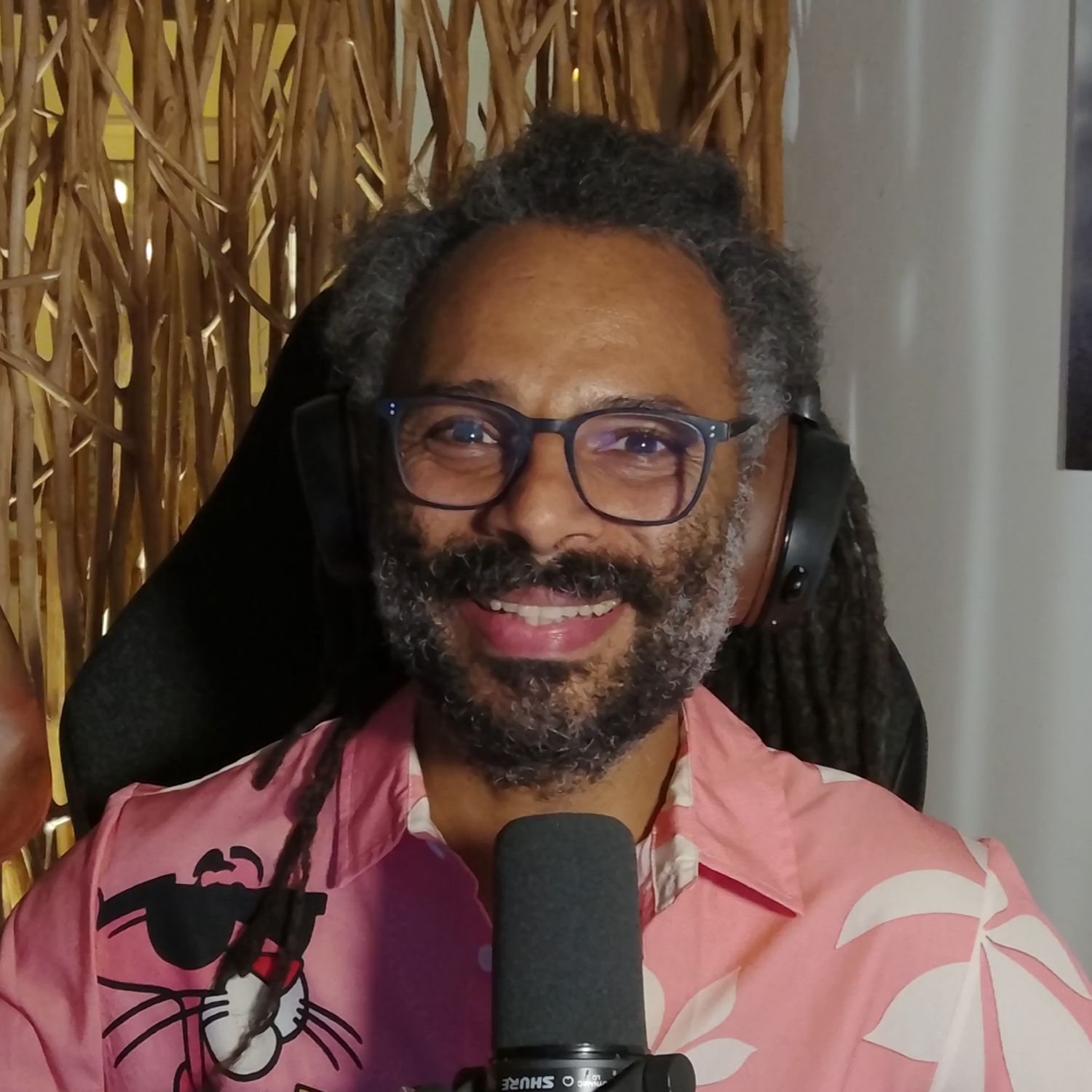 Brille, dunkelblauer Rahmen, rechteckige Gläser, Kopfhörer, rosa Hemd