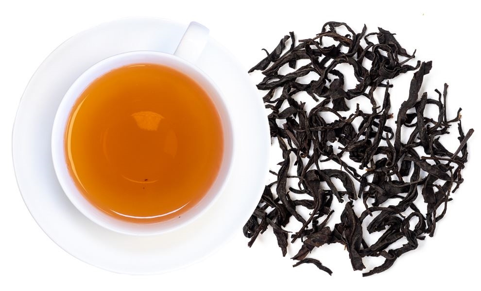 Weiße Tasse Schwarztee neben losem Schwarztee, tee, tee-blatt, schwarztee, getränk, kännchen