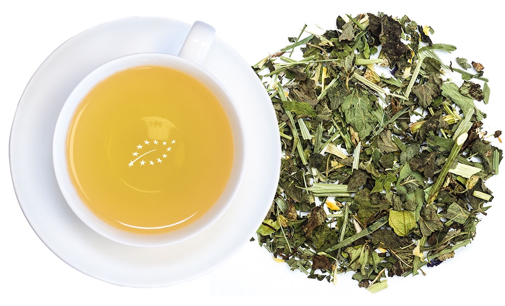 Weiße Tasse Kräutertee neben loser Kräutermischung, tee, teegetränk, getrocknete kräuter, grüner tee, tee blätter