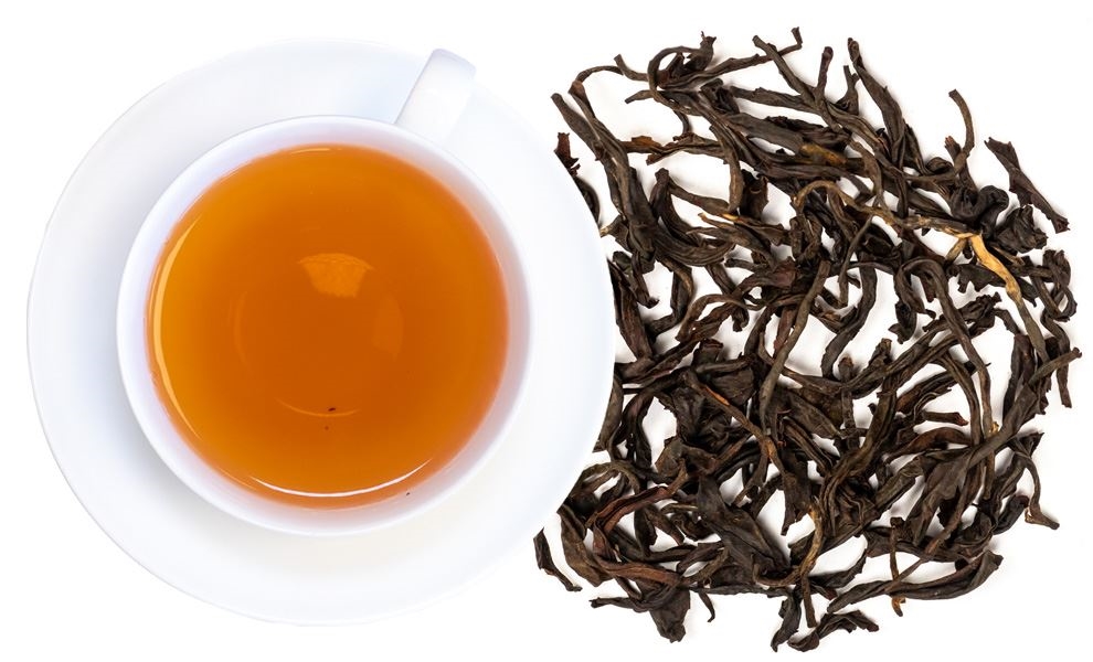 Weiße Tasse mit Schwarztee und losen Teeblättern, tee, getränk, blätter, schwarztee, kannen?