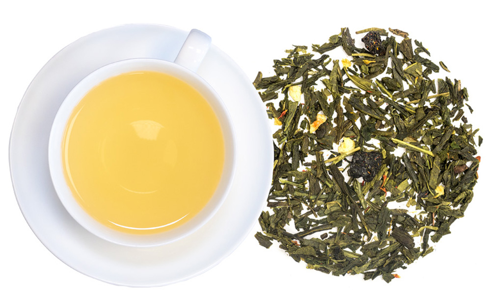 Weiße Tasse mit aufgebrühtem grünem Tee und Teeblättern