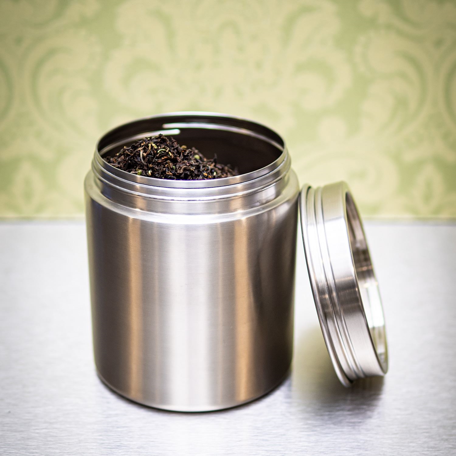 Offene Edelstahl-Teedose mit losem Schwarztee, Tee, Blechdose, Metalldose, Kühlschrankbehälter, Deckel