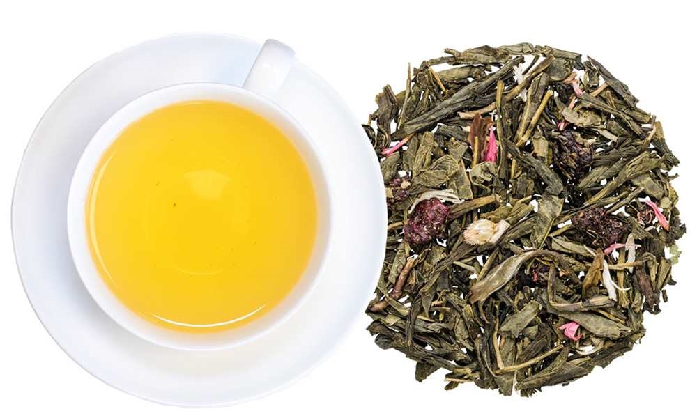 Tasse grüner Tee mit losem Früchtetee daneben, grünertee, tee, tee-blätter, tee-aufguss, loser-tee